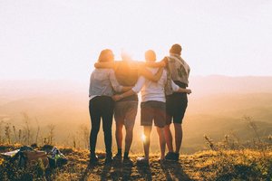 Four Friends Standing On The Top Of A Hill